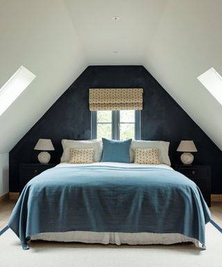 bedroom loft conversion with bed, blue wall and small bedside tables