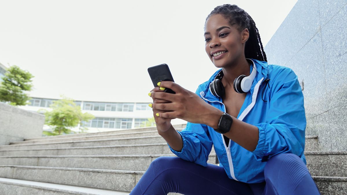 Runner sitting on steps using phone