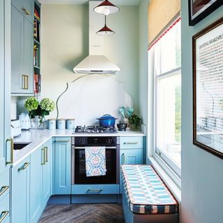 blue kitchen with bench seat and cooker hood
