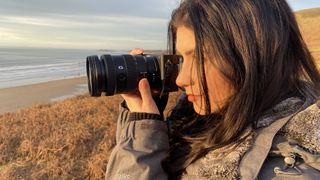 Sony E 16-55mm f/2.8 G Lens in the hands of the author at the coast