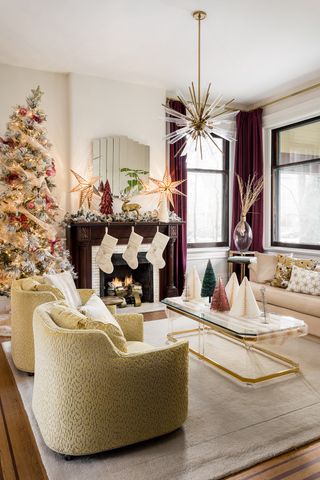 A living room with purple and green elements, and a large christmas tree in the corner