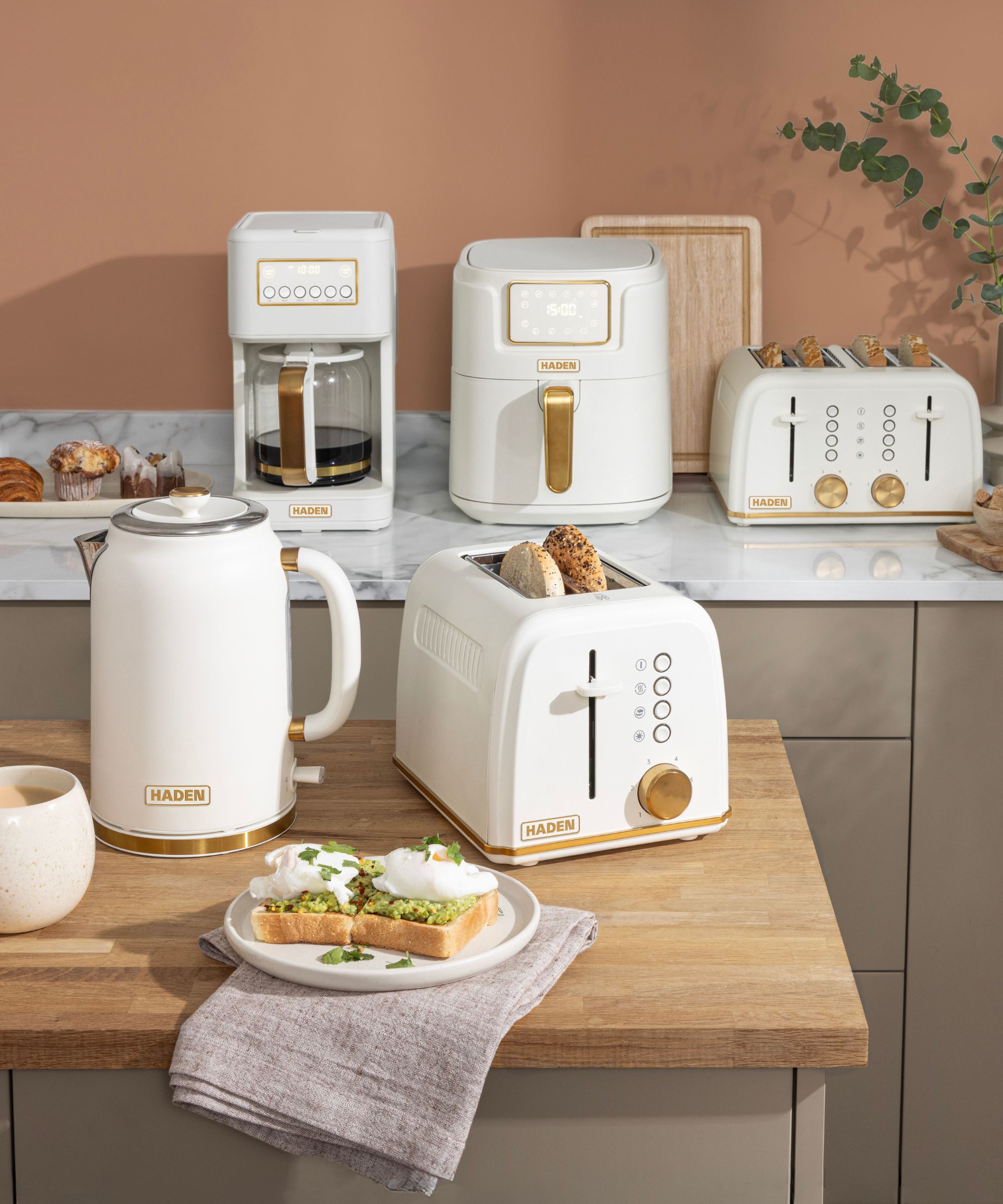 Mocha-colored kitchen with pale wooden counters and white appliances with brass handles