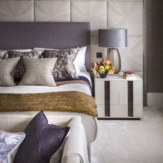 bedroom with grey headboard and cushions