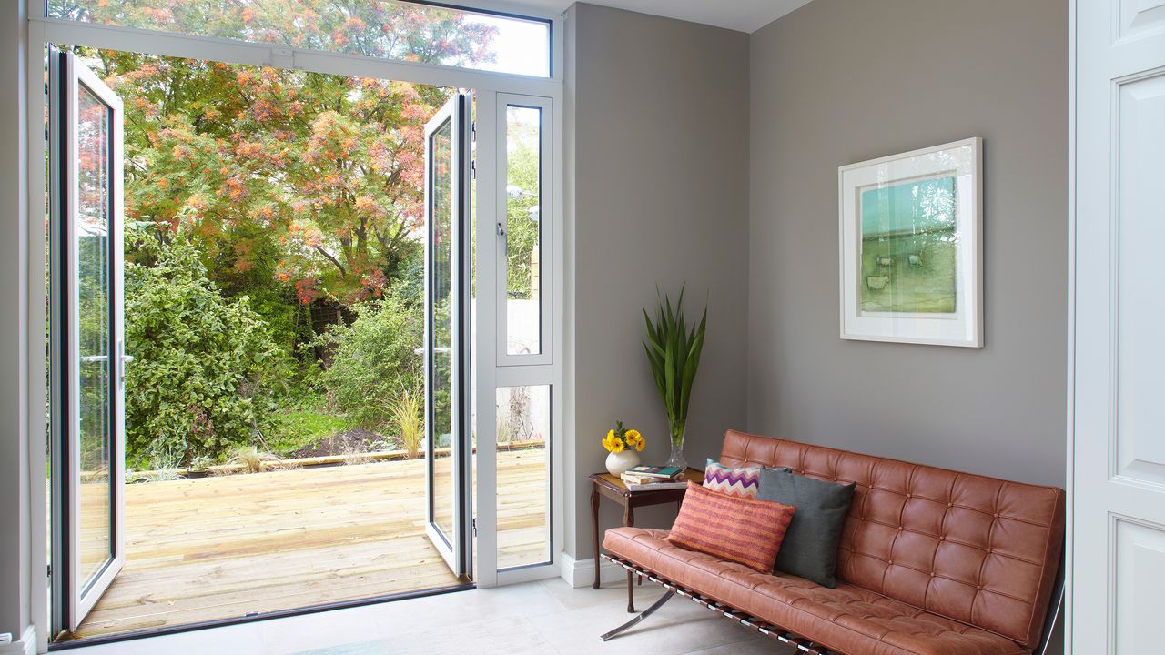 Grey living area with leather sofa and French doors leading out to garden