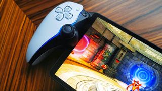 Close up of PlayStation Portal on woodgrain table with Crash Bandicoot 2 gameplay on screen.