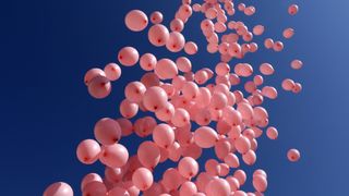 pink balloons released into sky