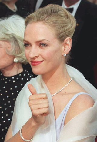 Actress Uma Thurman gives a thumb's up as she is greeted by fans as she arrives for the 67th Annual Academy Awards 27 March 1995 in Los Angeles
