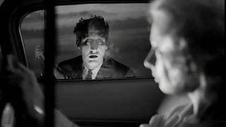 A ghastly figure at a car window in Carnival of Souls