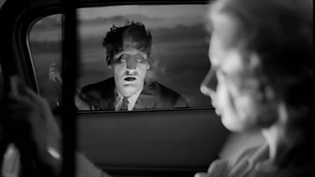 A ghastly figure at a car window in Carnival of Souls