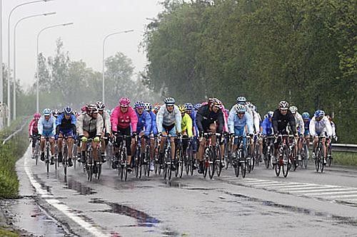 The bunch comes along in their rain jackets