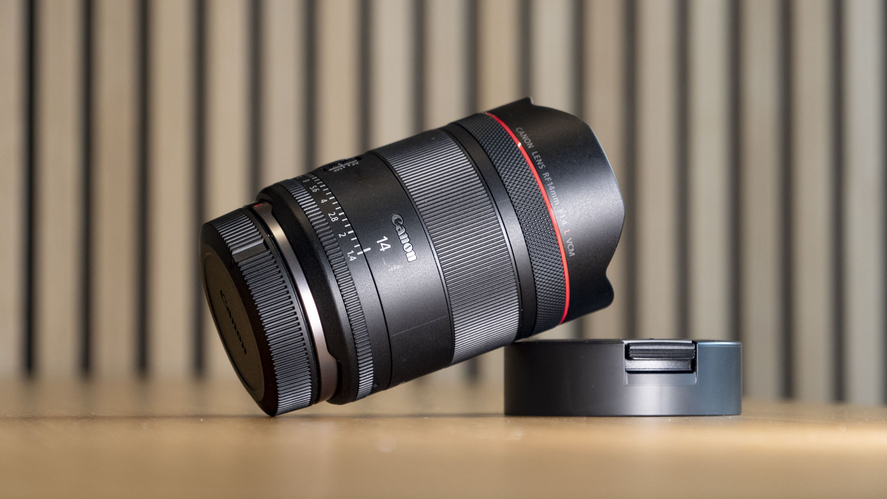 Canon RF 14mm F1.4L VCM lens on a wooden surface