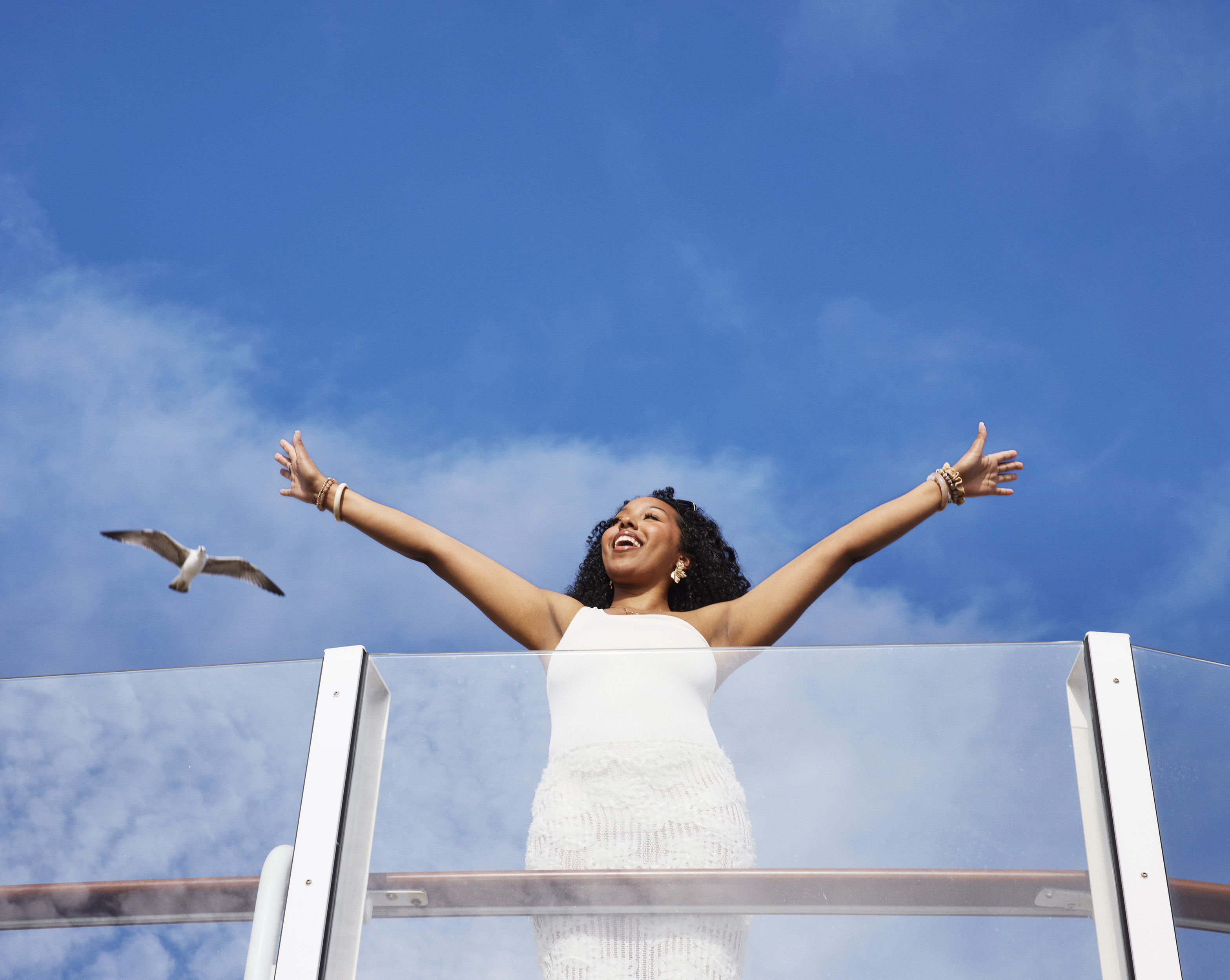 woman in white dress spreading arms wide