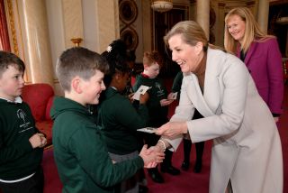 A year four schoolchild from Grange Park Primary School in Shropshire receives a commemorative Jubilee fifty pence coin, denoting the seventy years of the Queen's reign, from Sophie, Countess of Wessex to mark the successful completion of pupils achieving Junior Forester Award, following the planting of an elm tree as part of the Queen's Green Canopy (QGC) initiative to mark the Queen's Platinum Jubilee, in the gardens of Buckingham Palace on March 31, 2022 in London, England.