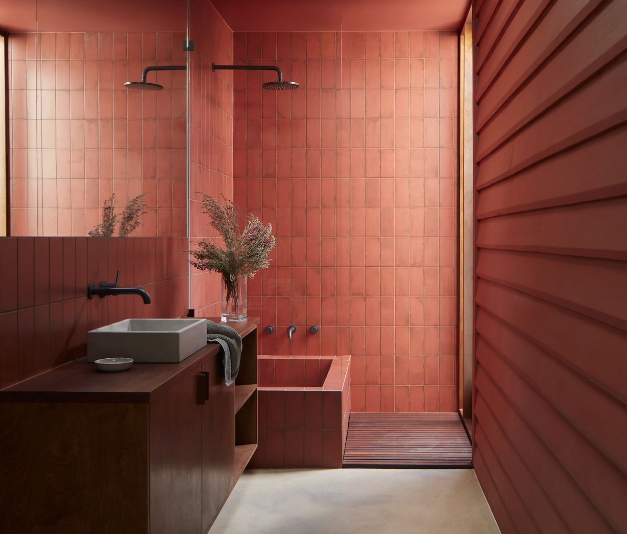 A red bathroom with red walls, shower and ceiling and a wooden cabinet