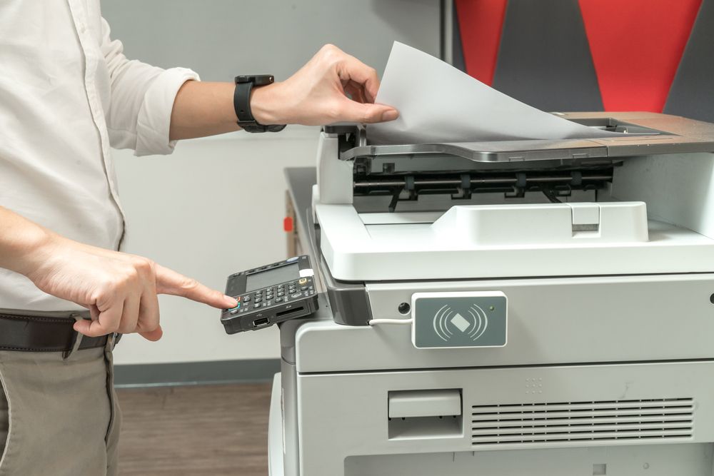 An office worker using a large printer