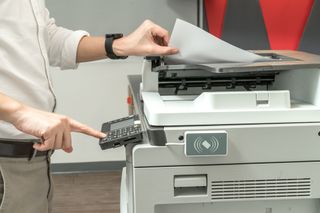 An office worker using a large printer