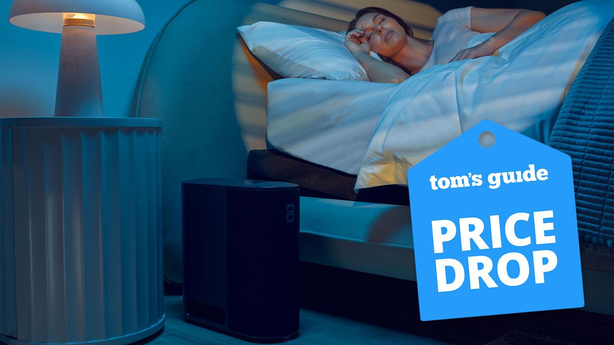 A woman lies in her bed at night, sleeping well. On the floor next to her is the Eight Sleep smart mattress cover Pod. A Tom&#039;s Guide Eight Sleep price drop deals graphic (left) representing best eight sleep discounts