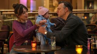 New mum Gemma (Aimee Lou Wood) hands baby Sadie to doting, yet hopeless, granddad Malcolm (David Morrissey) while enjoying drinks in an ambient setting for Daddy Issues season 2. 