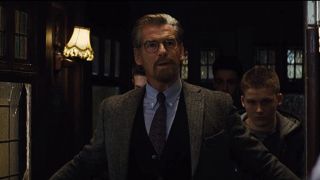 Pierce Brosnan walking into the room with young helpers in The World's End.