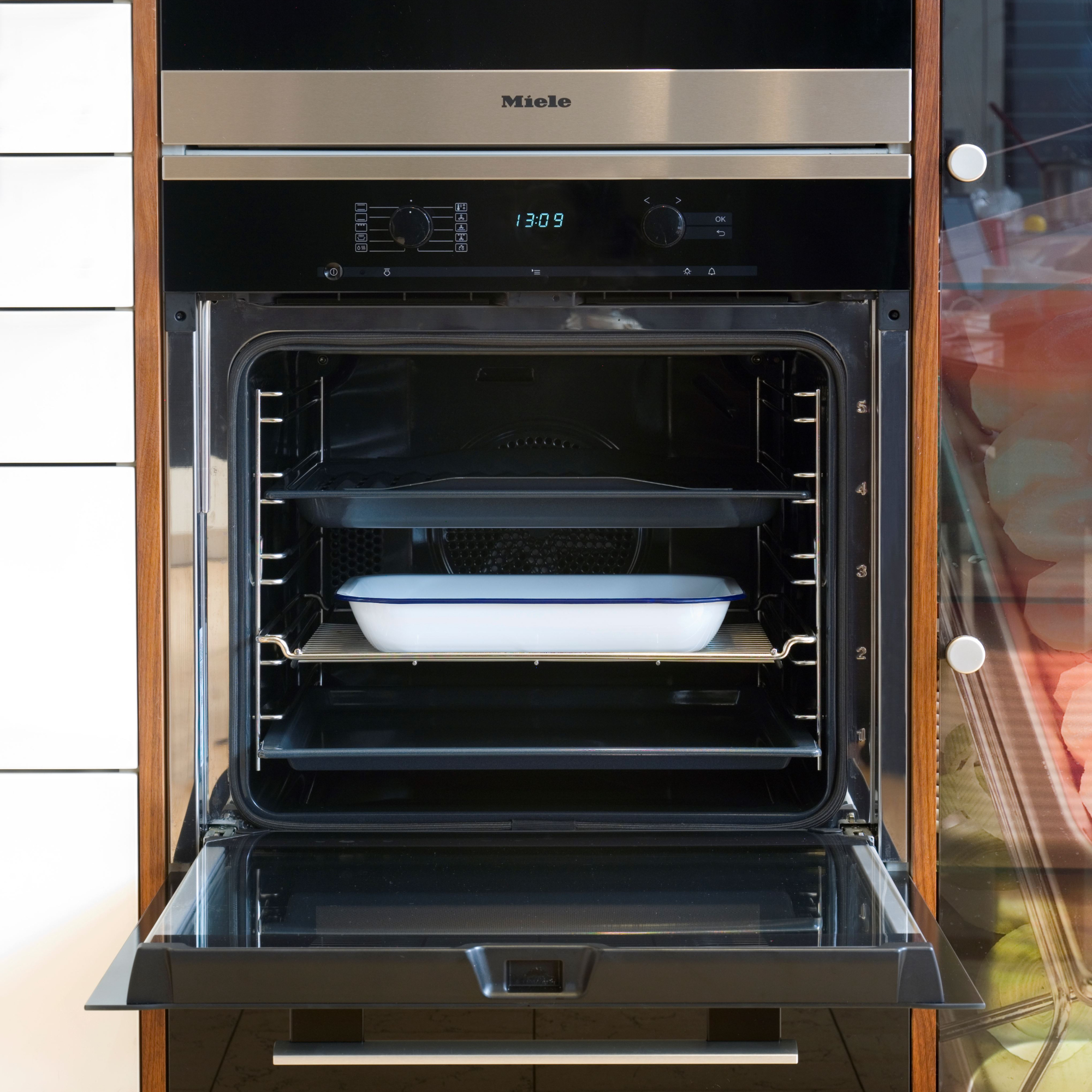 Close up of fitted black oven with ceramic oven-safe dish inside