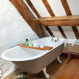 bathroom with bathtub wgite wall wooden beam on ceiling and wooden flooring
