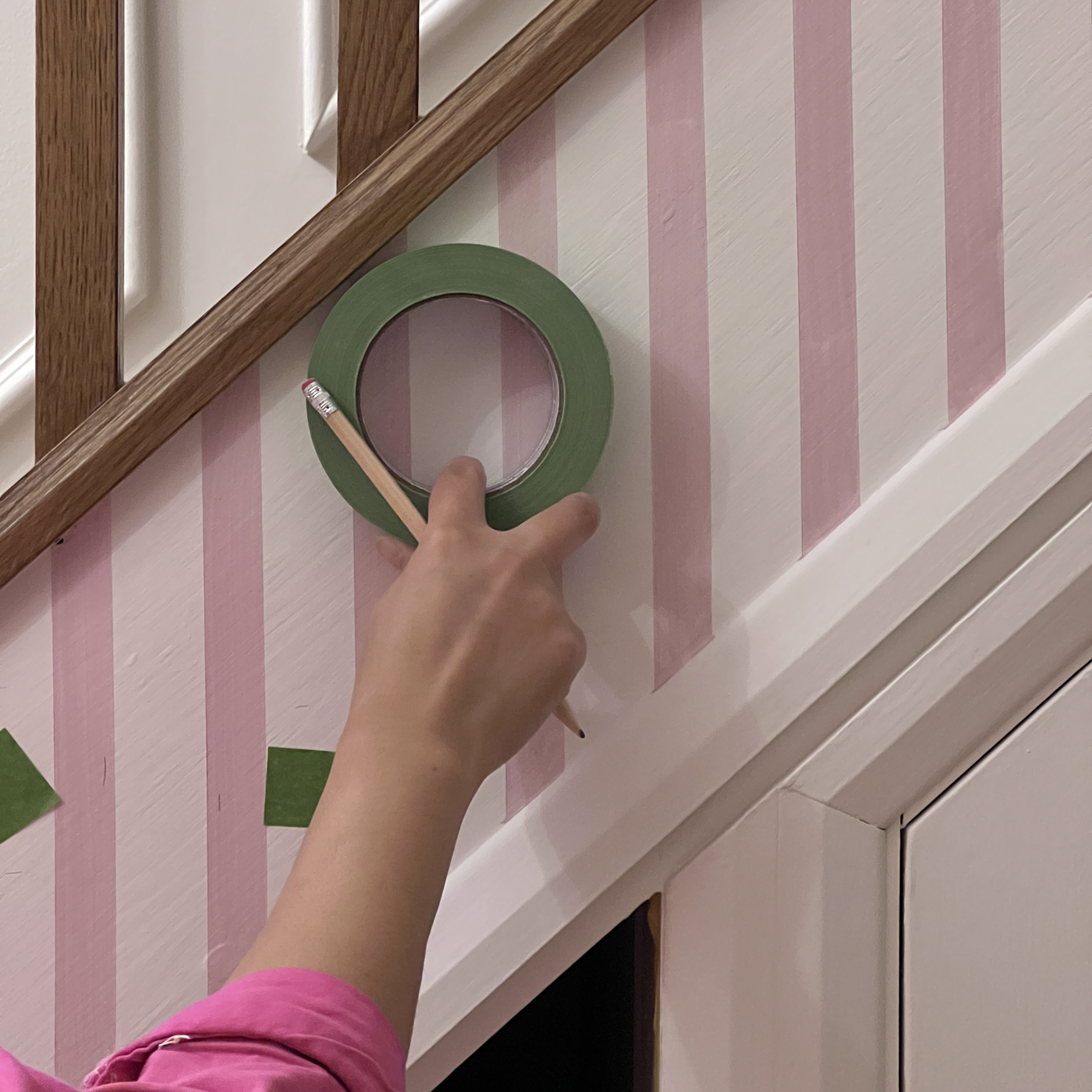 using masking tape to paint stripes on a stairway