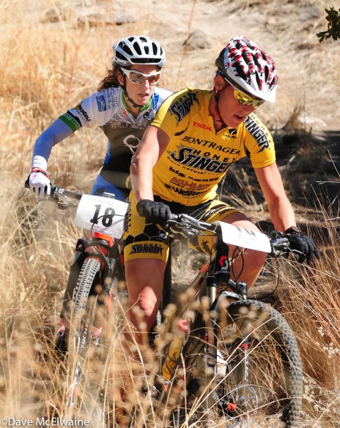 Jaime Brede (Honey Stinger/Bontrager) leading Beth Utley throgh the tall grass