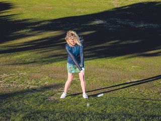 Katie Dawkins demonstrating a shot with the golf ball above her feet