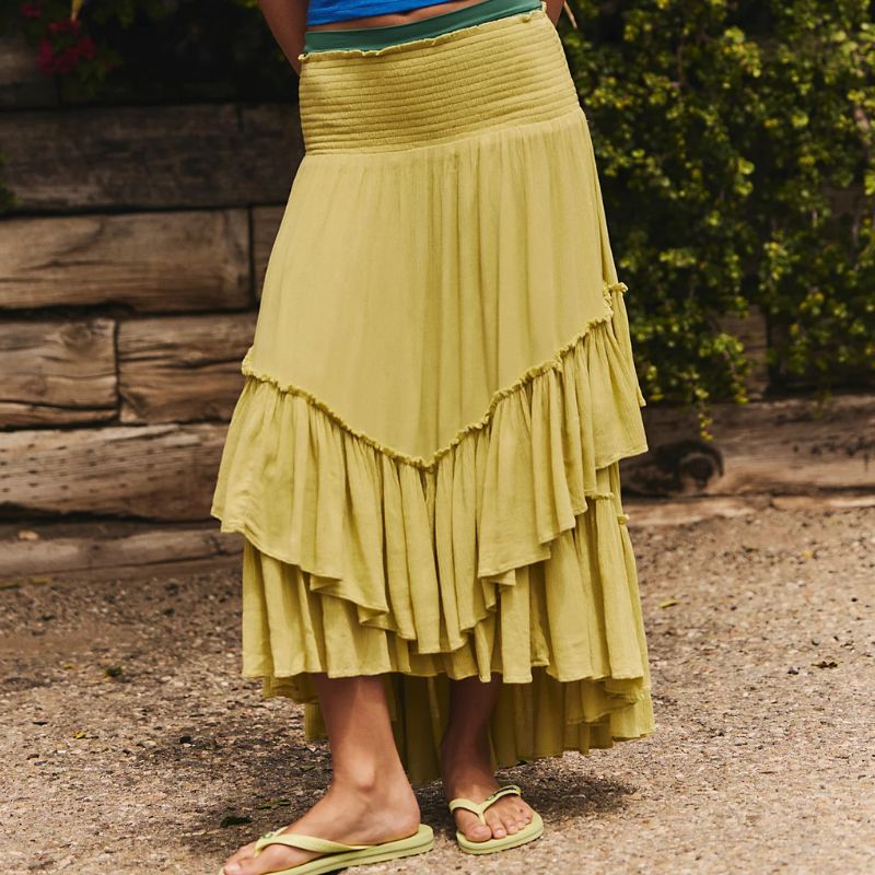 A woman wears a lime green Free People maxi skirt