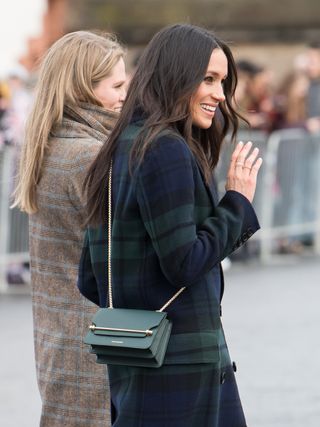 meghan markle wears a navy plaid coat and a dark green crossbody bag from strathberry