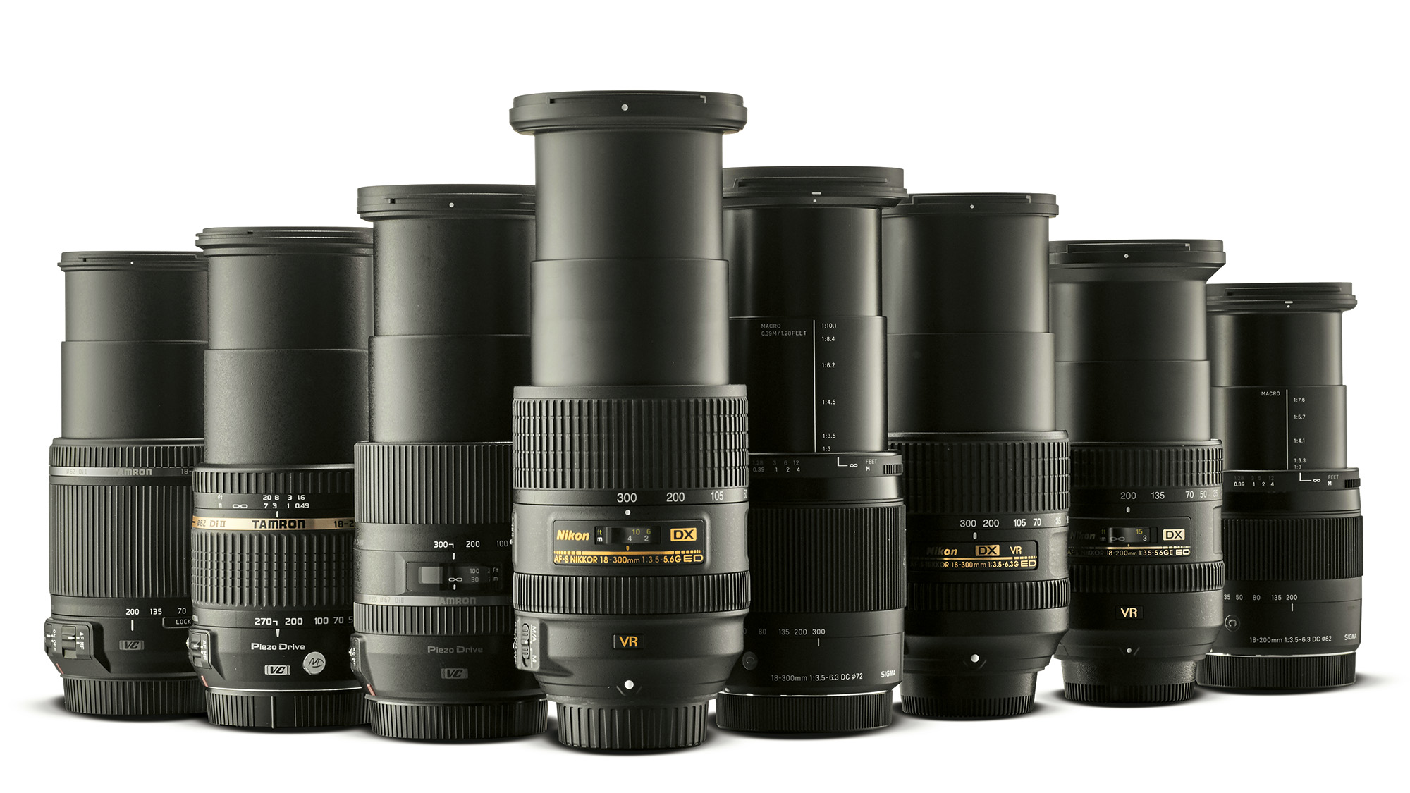 Eight Nikon-fit lenses in a row on a white background