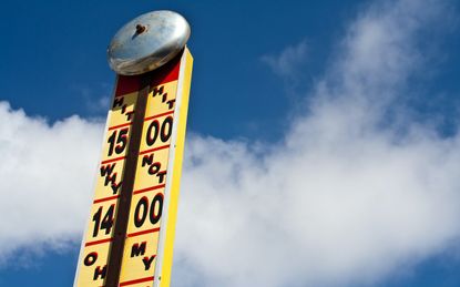 Ring the bell and win a prize.Fairground strength tester with a cloudy blue sky background. A very bright and positive image With lots of copy space.