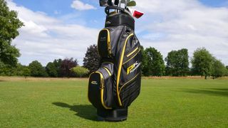 The black and yellow PowaKaddy X-Lite Cart Bag Resting on the golf course