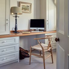 Home office workstation with white cupboards and large desk lamps