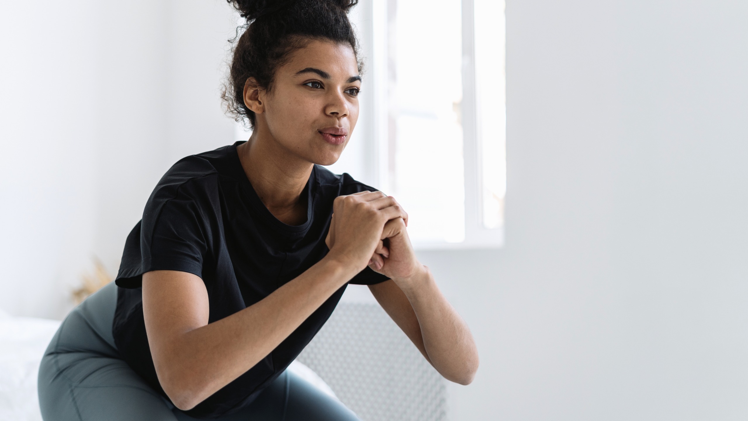 A woman performs a bodyweight squat as part of a legs workout