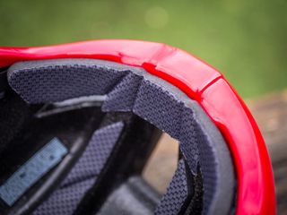 A red Kask Utopia Y aero helmet sits on a wooden bench