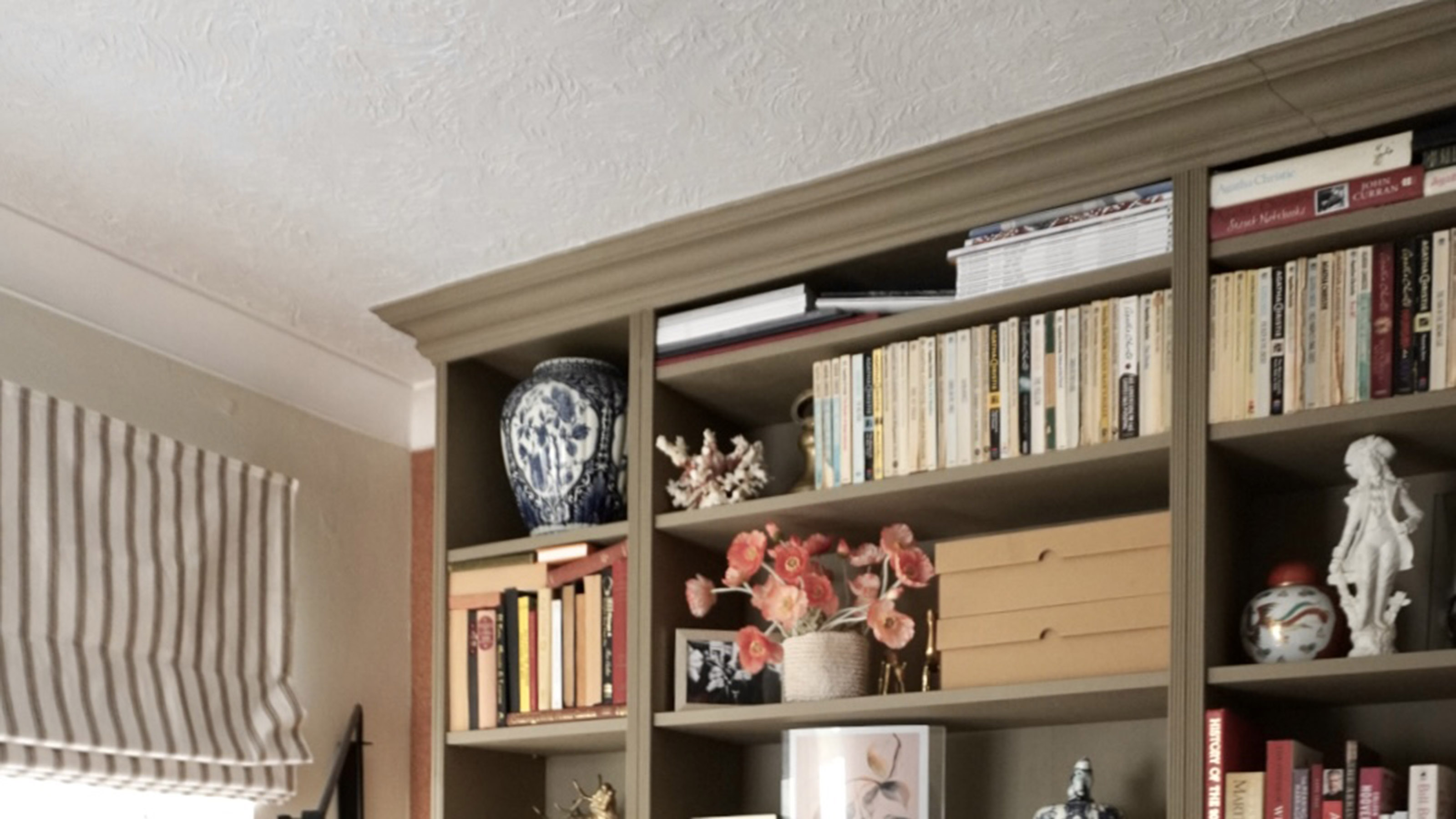 brown bookcase filled with books and ornaments