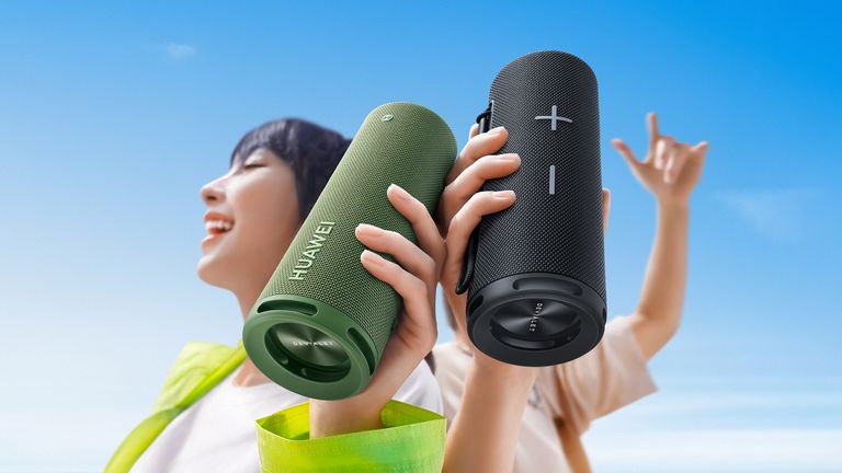 Huawei Sound Joy in green and black, held by two people against a blue sky
