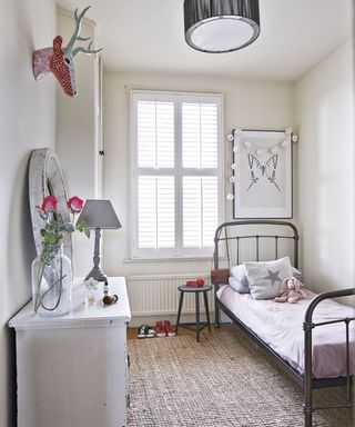 child room with white wall and bed