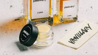lush vanillary solid perfume with liquid perfume bottles in the background