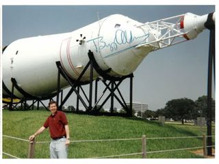 In a photo taken by his father, NASA lunar scientist Noah Petro stands in front of an Apollo-era Saturn V rocket on display at NASA's Johnson Space Center. Denis Petro later had the photo signed by Apollo astronaut Buzz Aldrin.