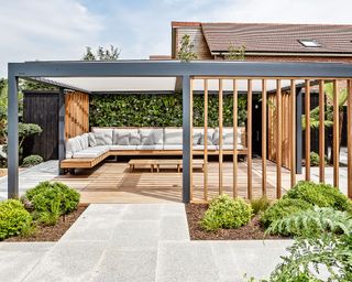 Outdoor living room with steel-framed pergola and wood