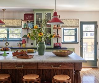 Traditional farmhouse kitchen with kitchen island disguised as a farmhouse table in warm wood tones