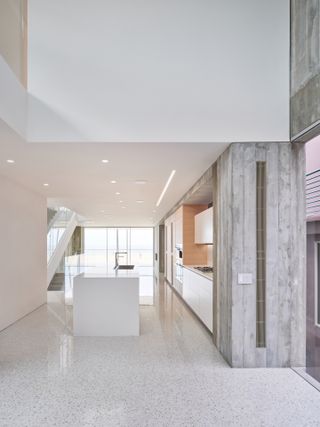 Venice Beach house by Dan Brunn, showing interior with exposed concrete and sleek white kitchen