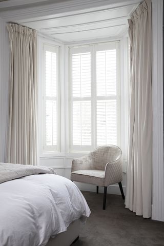 white bedroom with curtians and shutters