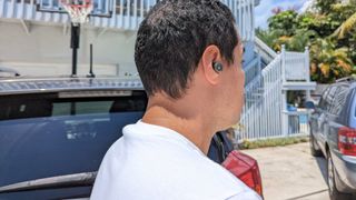 Reviewer outside wearing Edifier W240TN earbuds and testing ANC performance