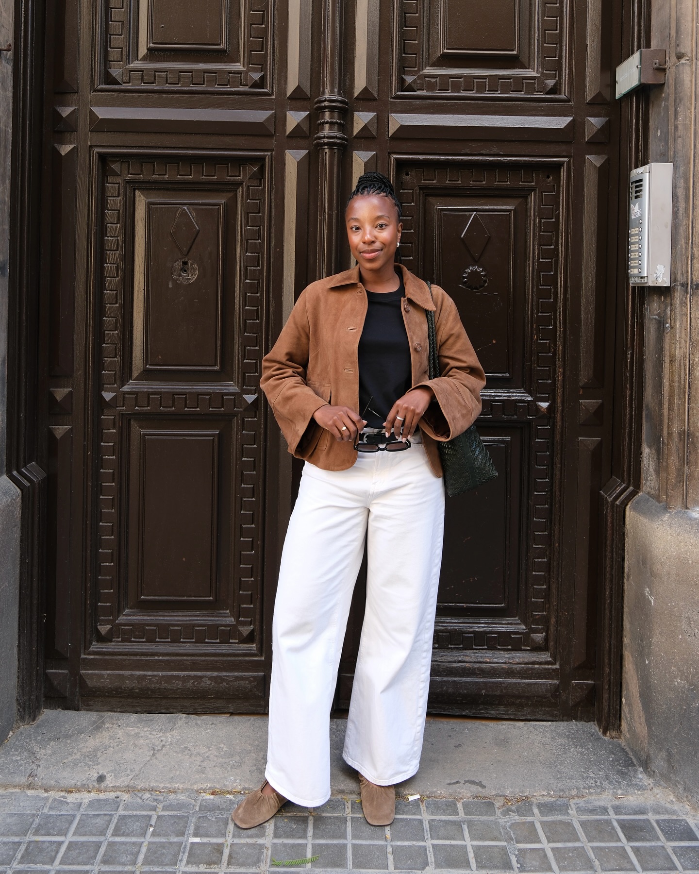 Taffy wears a brown suede jacket, black T-shirt, white jeans and brown loafers