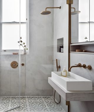 A wet room Idea for small bathrooms with a frameless screen and smooth grey walls