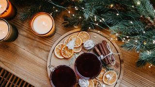 christmas garland next to a tray with with lights, mulled wine and dried fruit