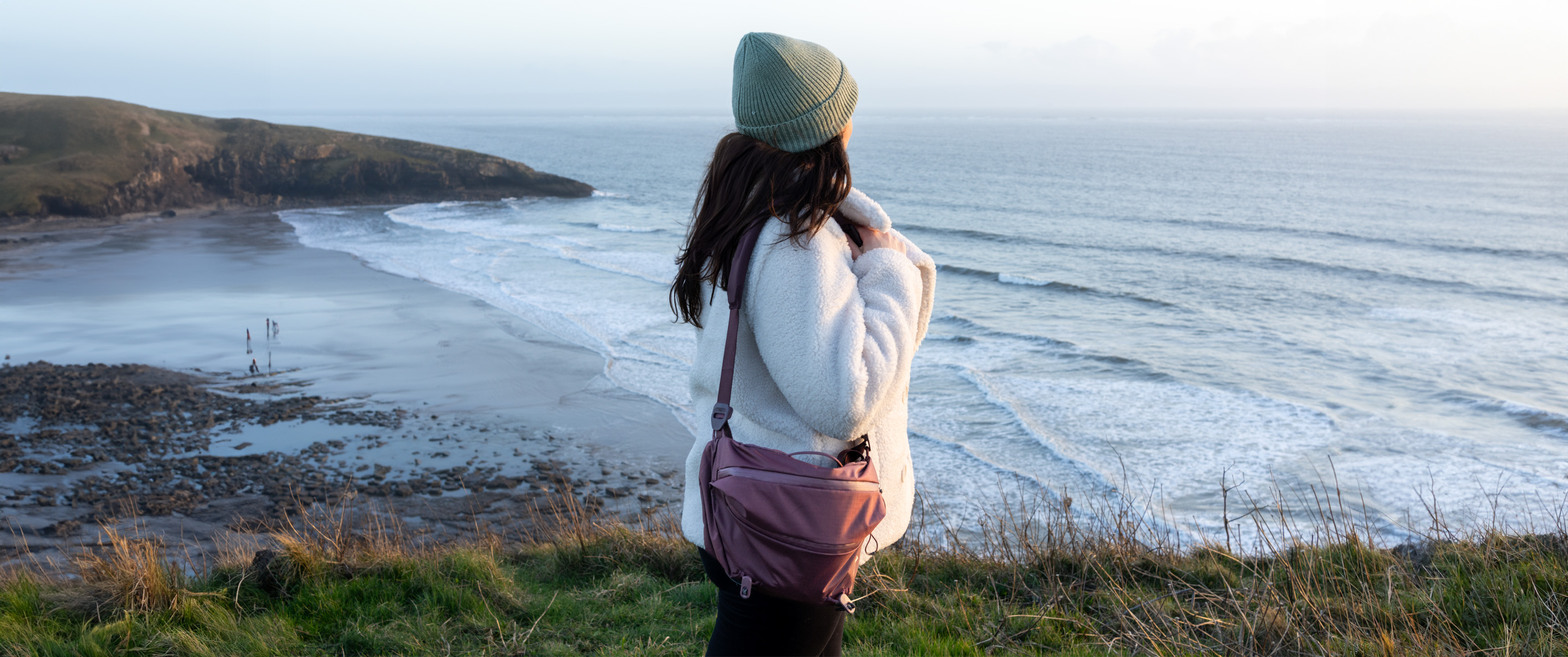 woman wearing the peak design sling bag at a coastal location